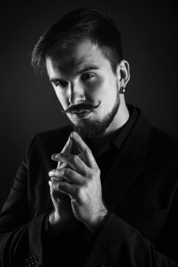 koyu arka plan üzerinde sakallı yakışıklı acımasız adam