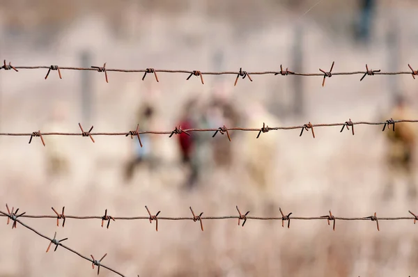 Old Rusty Barbed Wire Fence Blurred Figures People — Stock Photo, Image