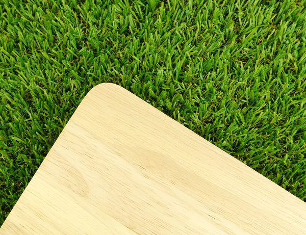 Wood board on green grass — Stock Photo, Image