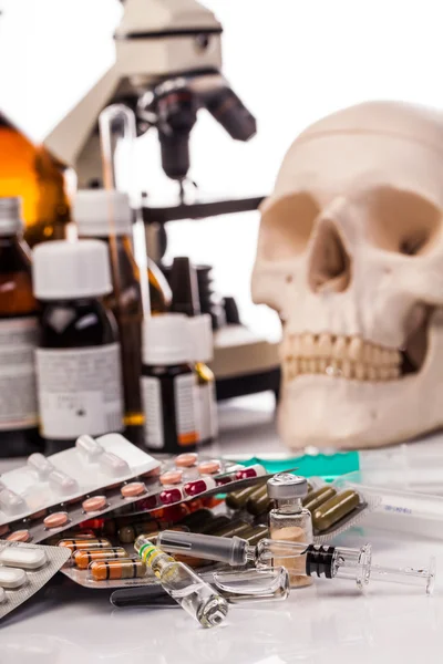 Medikamente, menschlicher Schädel und Mikroskop — Stockfoto