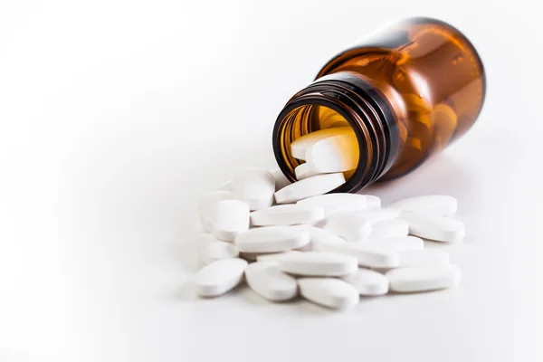 Tabletták és barna üvegben — Stock Fotó