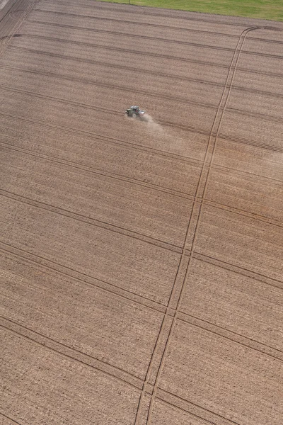 Трактор працює на полі врожаю — стокове фото