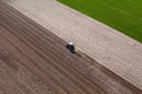 Trattore che lavora sul campo di raccolta — Foto Stock