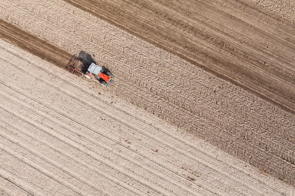 Trator que trabalha no campo de colheita — Fotografia de Stock