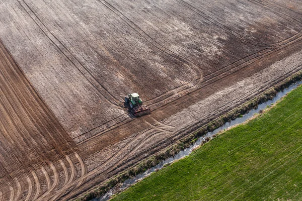 Trekker werken op het gebied van de oogst — Stockfoto