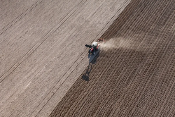 Traktor som arbetar på fältet skörd — Stockfoto