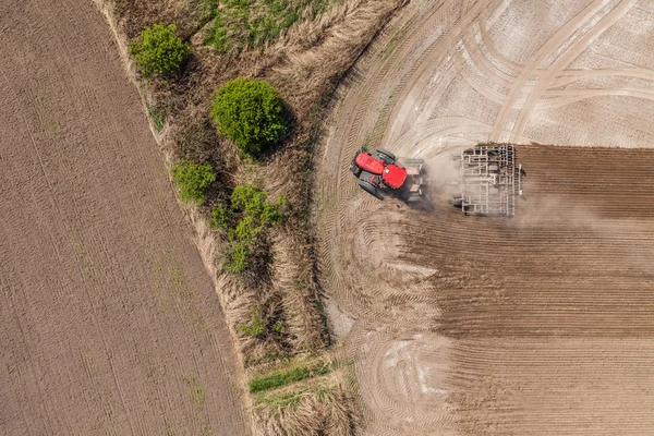 Трактор працює на полі врожаю — стокове фото