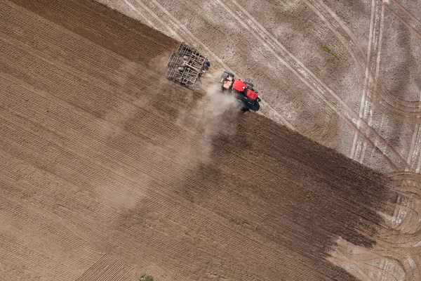 Trekker werken op het gebied van de oogst — Stockfoto