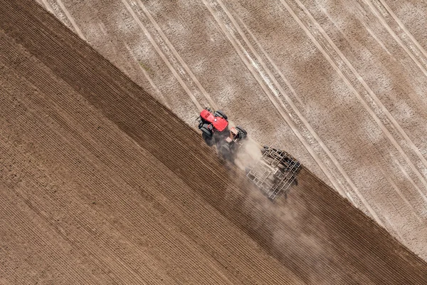 Trator que trabalha no campo de colheita — Fotografia de Stock