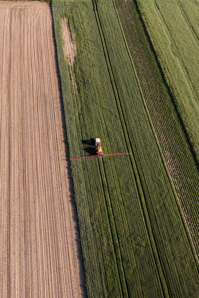 Aerial view of the tractor on harvest field