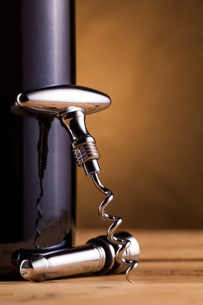 Wine bottle and corkscrew on table — Stock Photo, Image