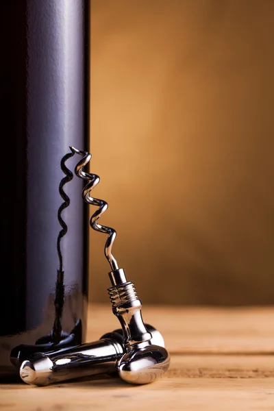 Botella de vino y sacacorchos en la mesa — Foto de Stock