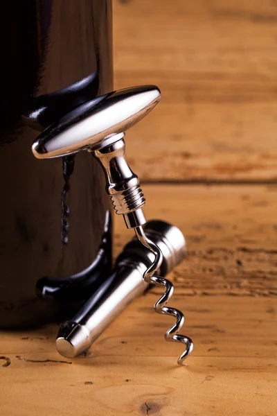 Wine bottle and corkscrew on table — Stock Photo, Image