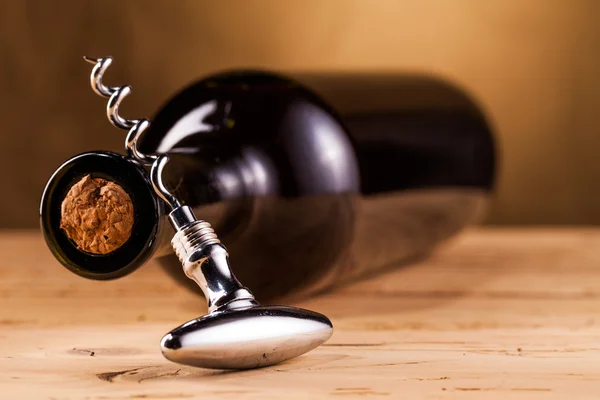 Botella de vino y sacacorchos en la mesa — Foto de Stock