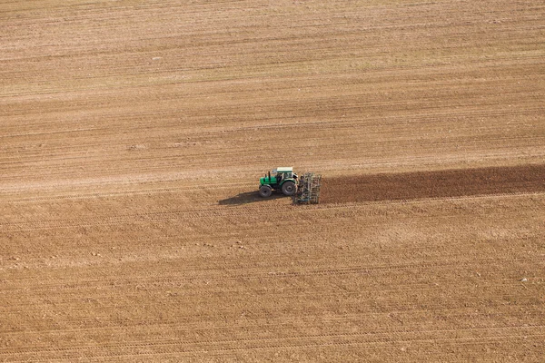 Skörden fält med traktor — Stockfoto