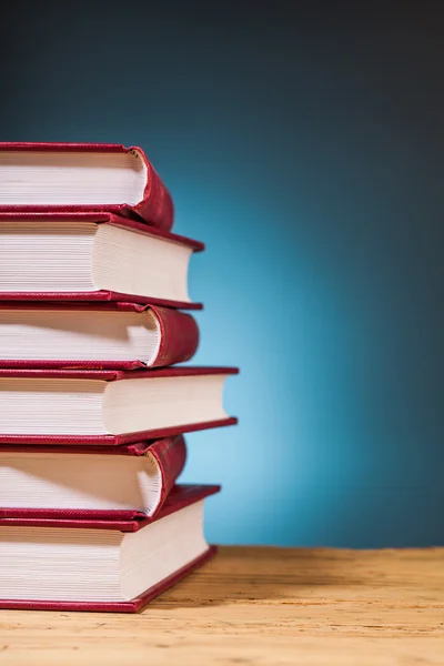 Pilha de livros sobre mesa de madeira — Fotografia de Stock