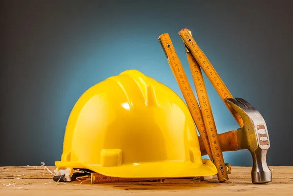 Yellow helmet and wood mounting tools — Stock Photo, Image