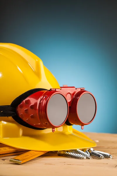 Capacete amarelo e ferramentas de montagem de madeira — Fotografia de Stock