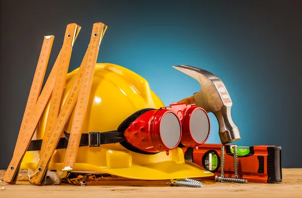 Casco giallo e strumenti di montaggio in legno — Foto Stock