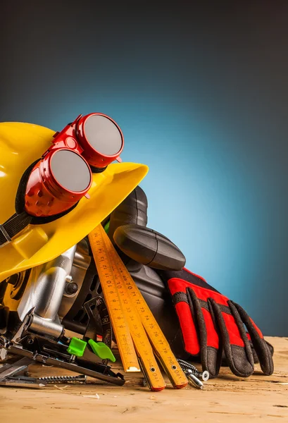 Casco giallo e strumenti di montaggio in legno — Foto Stock