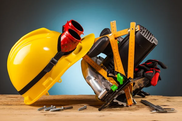 Capacete amarelo e ferramentas de montagem de madeira — Fotografia de Stock