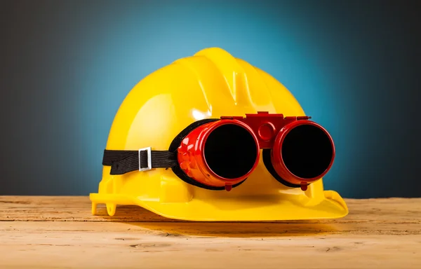 Gele helm op tafel — Stockfoto