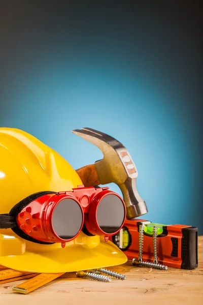 Capacete amarelo e ferramentas de montagem de madeira — Fotografia de Stock