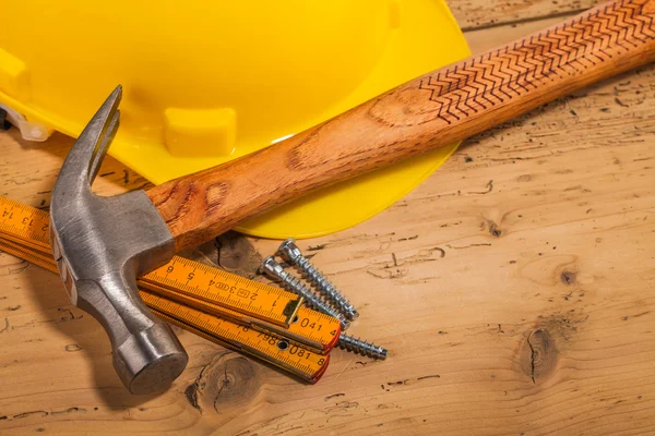 Casco amarillo, martillo y herramientas de montaje — Foto de Stock