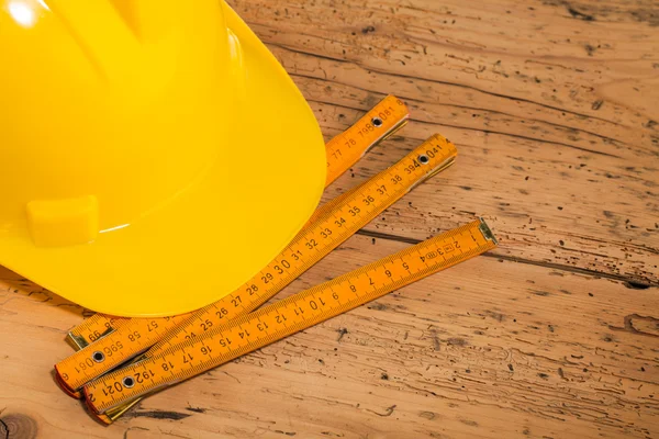 Yellow helmet and measuring tool — Stock Photo, Image