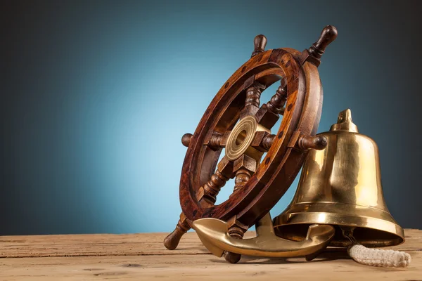 Anchor bell and old wooden steering wheel — Stock Photo, Image