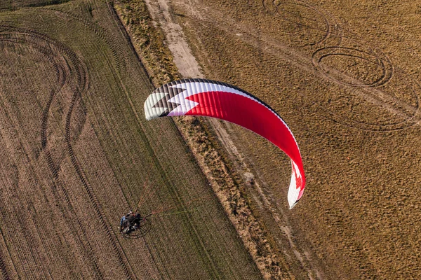 Aerial view of paramotor flying over the harvest field — Stock Photo, Image