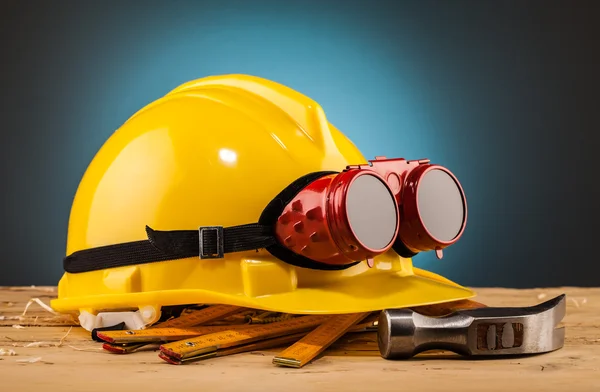 Capacete amarelo e ferramentas de montagem de madeira — Fotografia de Stock