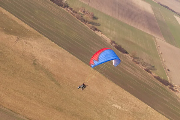 Paramotor voando sobre o campo de colheita — Fotografia de Stock