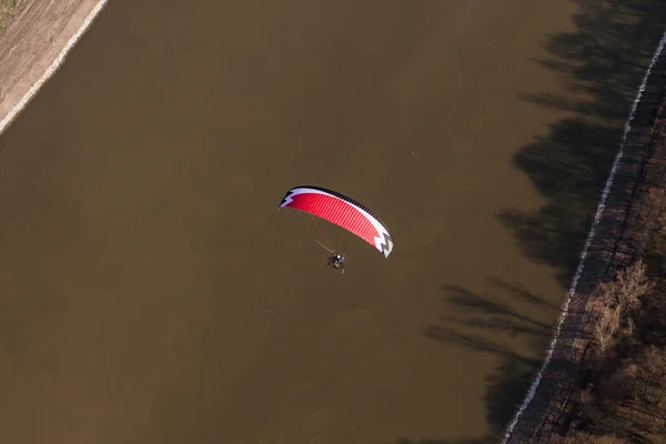 Aerial view of paramotor flying over the river — Stock Photo, Image