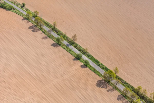 Vista aérea de la carretera del pueblo y campos de cosecha — Foto de Stock