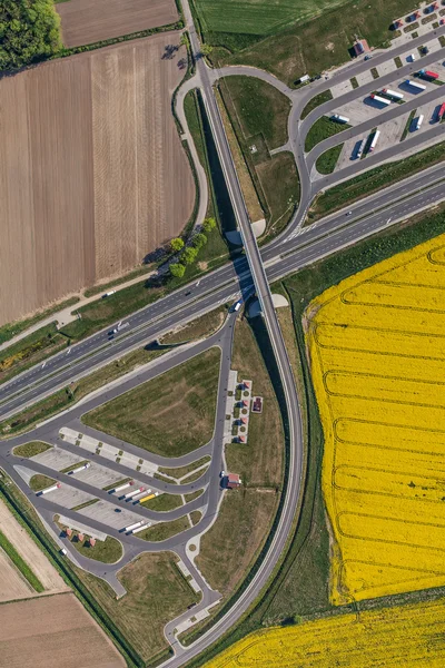 Aerial view of highway and green, yellow harvest fields — Stock Photo, Image