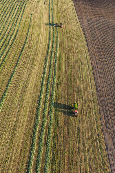 aerial view of harvest fields with combine and tractor 