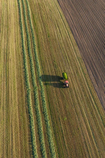 Вид с воздуха на поля для сбора урожая с комбайном и трактором — стоковое фото
