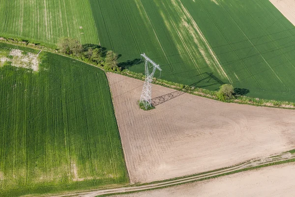 Imagem aérea de campos de colheita e fios elétricos com grandes s — Fotografia de Stock