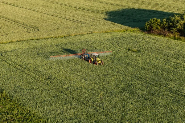 Widok z lotu ptaka pola zbiorów z ciągnikiem — Zdjęcie stockowe