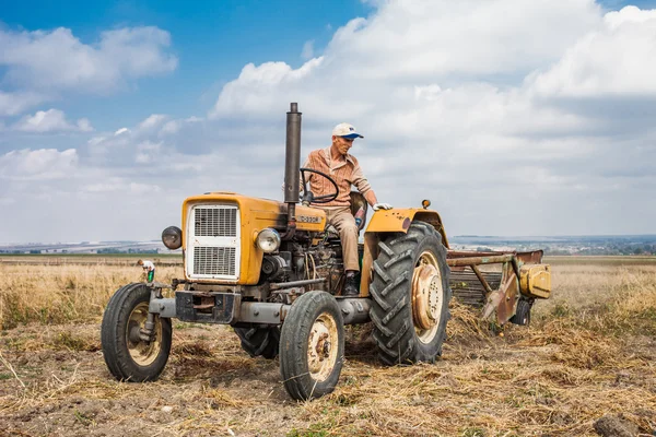 Alter Traktor auf Erntefeld - Stockfotografie: lizenzfreie Fotos