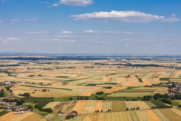 Aerial view of the blue sky and village harvest fields in Poland
