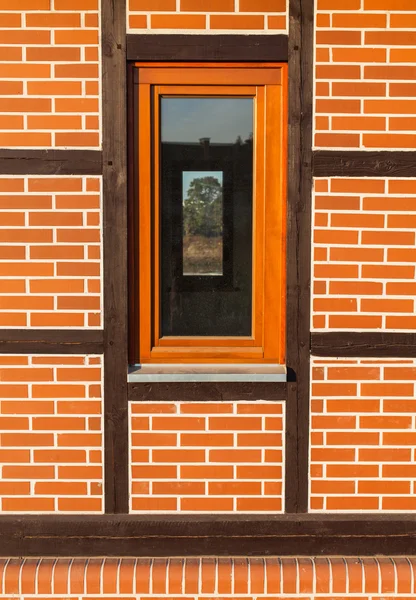 Rote Backsteinmauer mit schmalem Fenster — Stockfoto