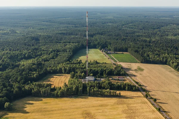 Torre de comunicação entre campo e floresta — Fotografia de Stock