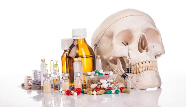 Diverse medicijnen, injectienaalden en schedel — Stockfoto
