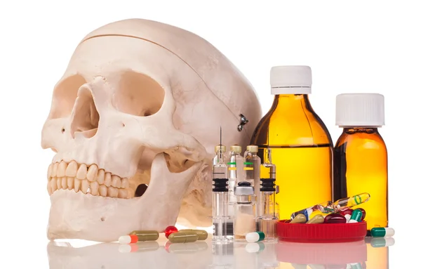 Medicines, human skull and syringes — Stock Photo, Image