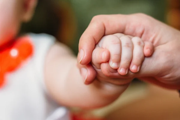 Mão do bebê nos braços da mãe Fotos De Bancos De Imagens