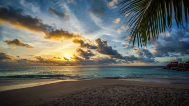 Seyşel Adaları 'ndaki cennet plajında altın bir günbatımı.