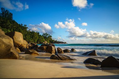 Granit kayalar ve gölgeleriyle cennet tropik sahillerinde güzel bir gün batımı. Anse intendance 'de kum turkuaz suyu..