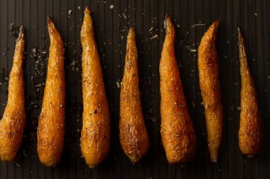 Bütün kavrulmuş havuç ile bir tavada baharat. Sağlıklı yemek